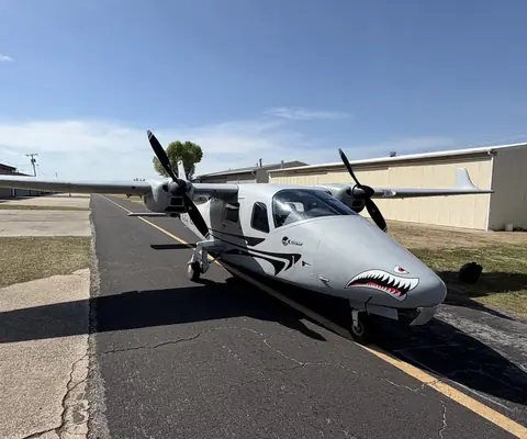 N977GV, a gray Tecnam P2006T twin with shark mouth nose art, on the taxiway