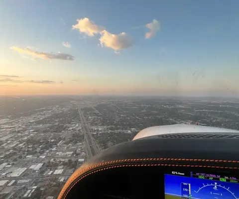View over the city at sunset from the cockpit while flying